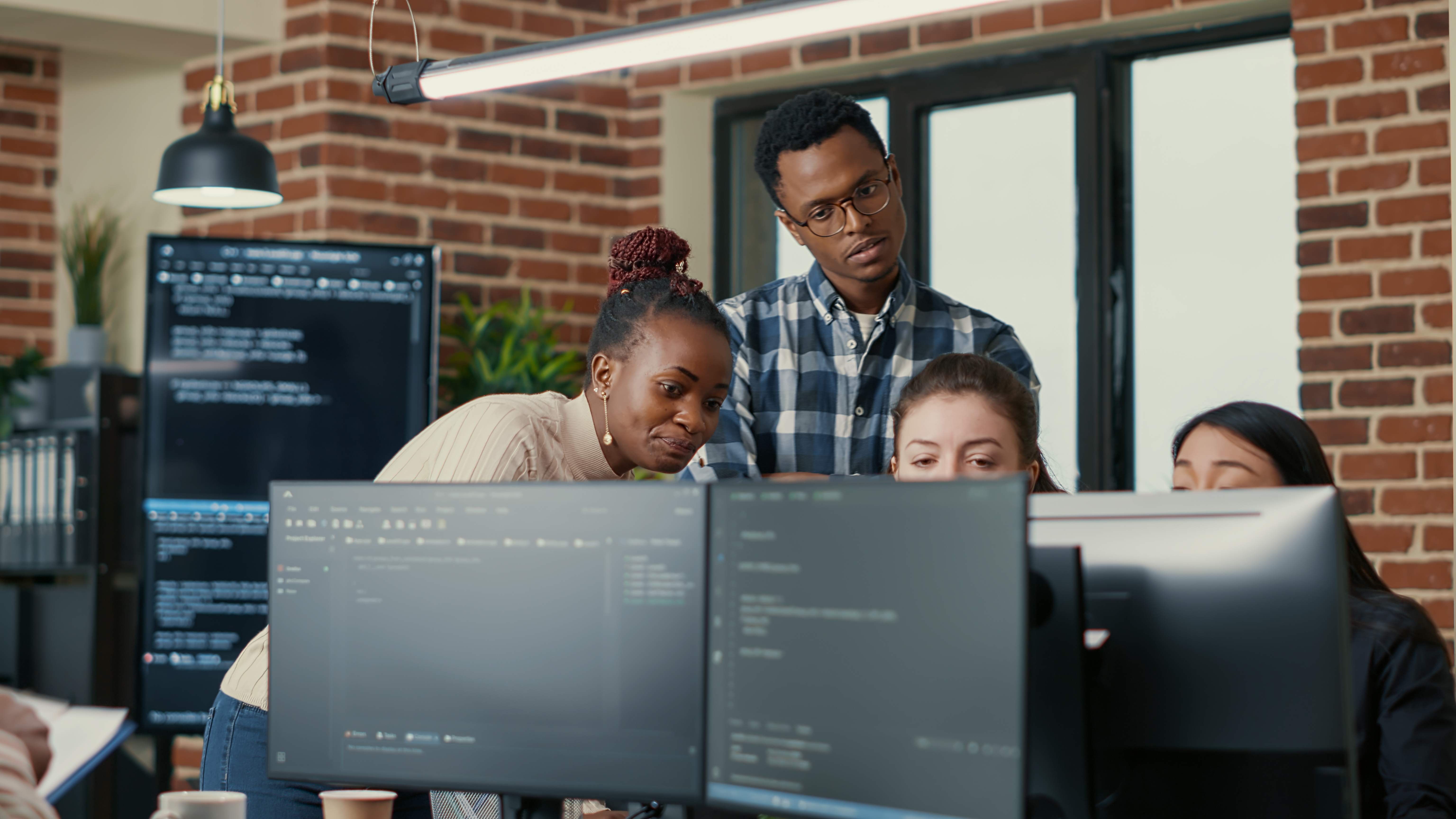 Software developers collaborating around laptops