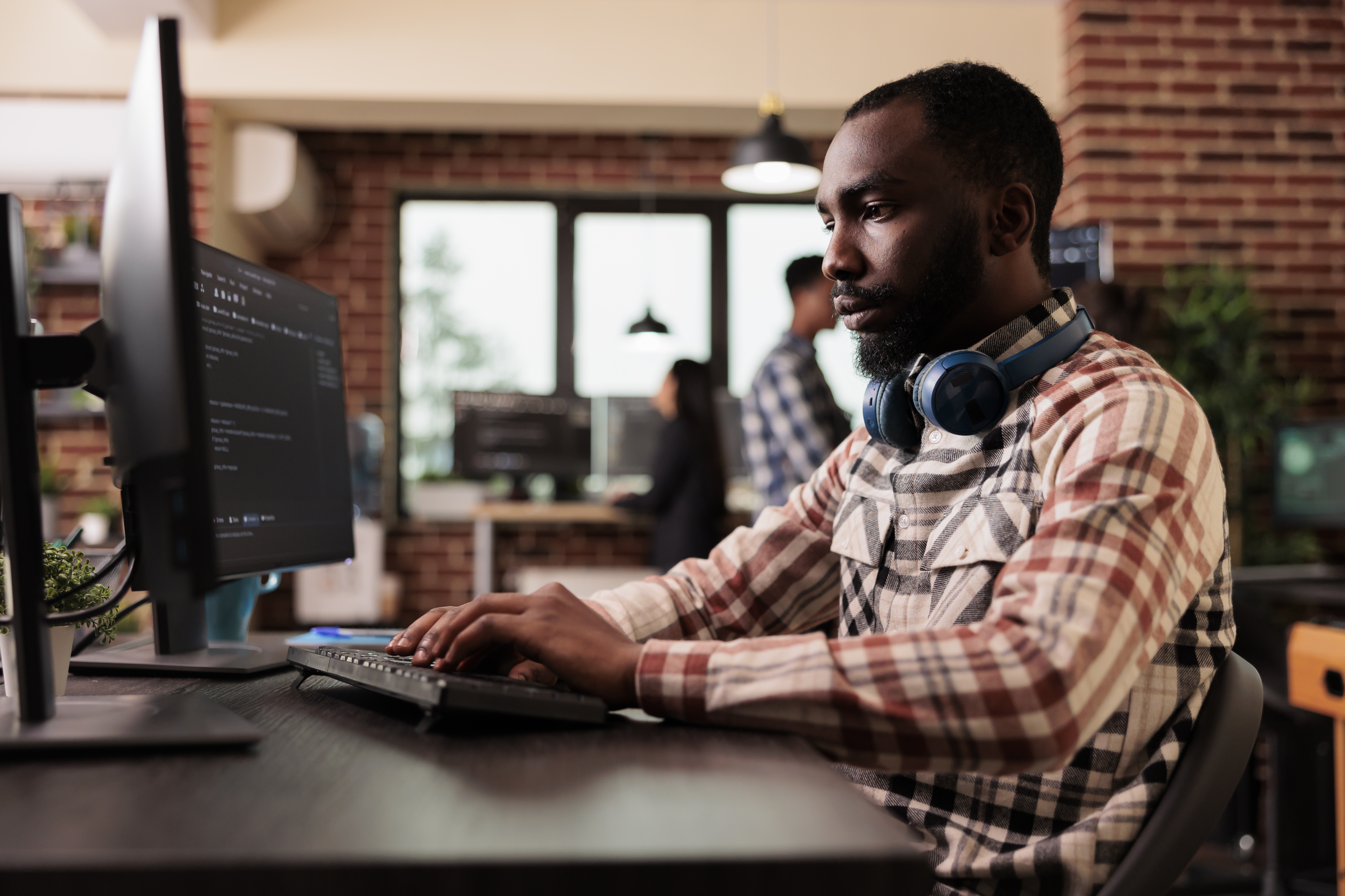 Software developer coding at a monitor
